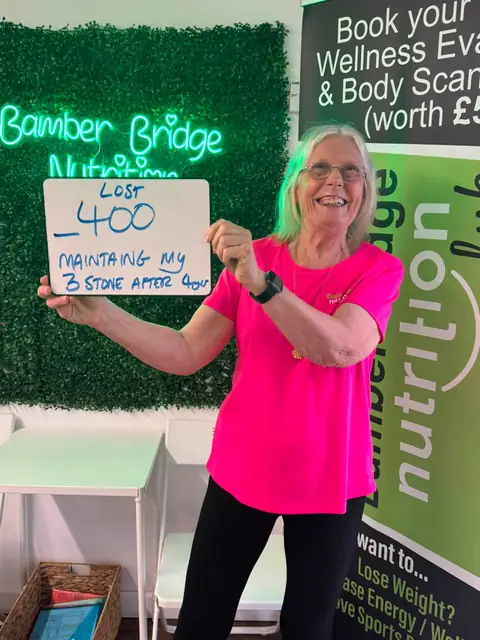 At the Bamber Bridge club, a member holding up the board with her results
